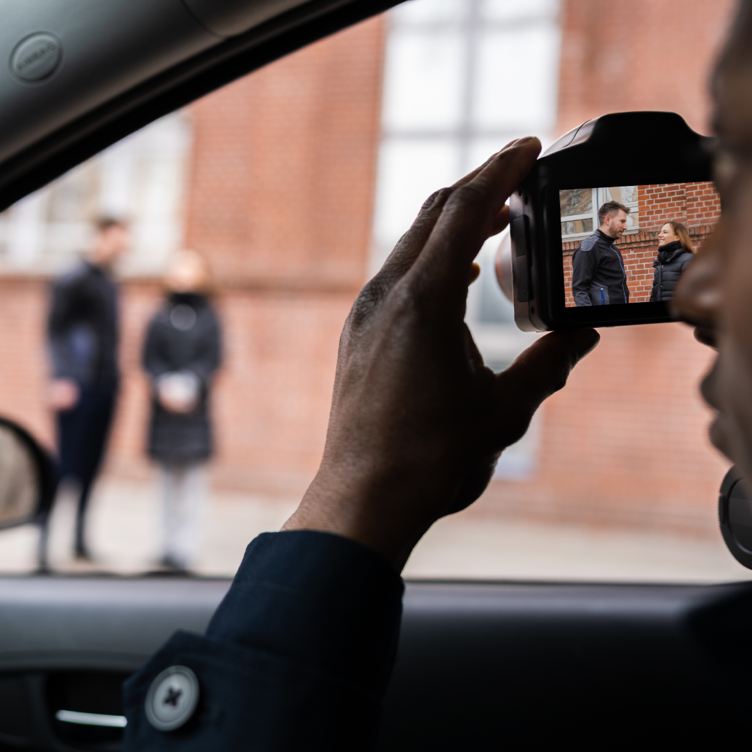A man is taking a picture of two people in a car