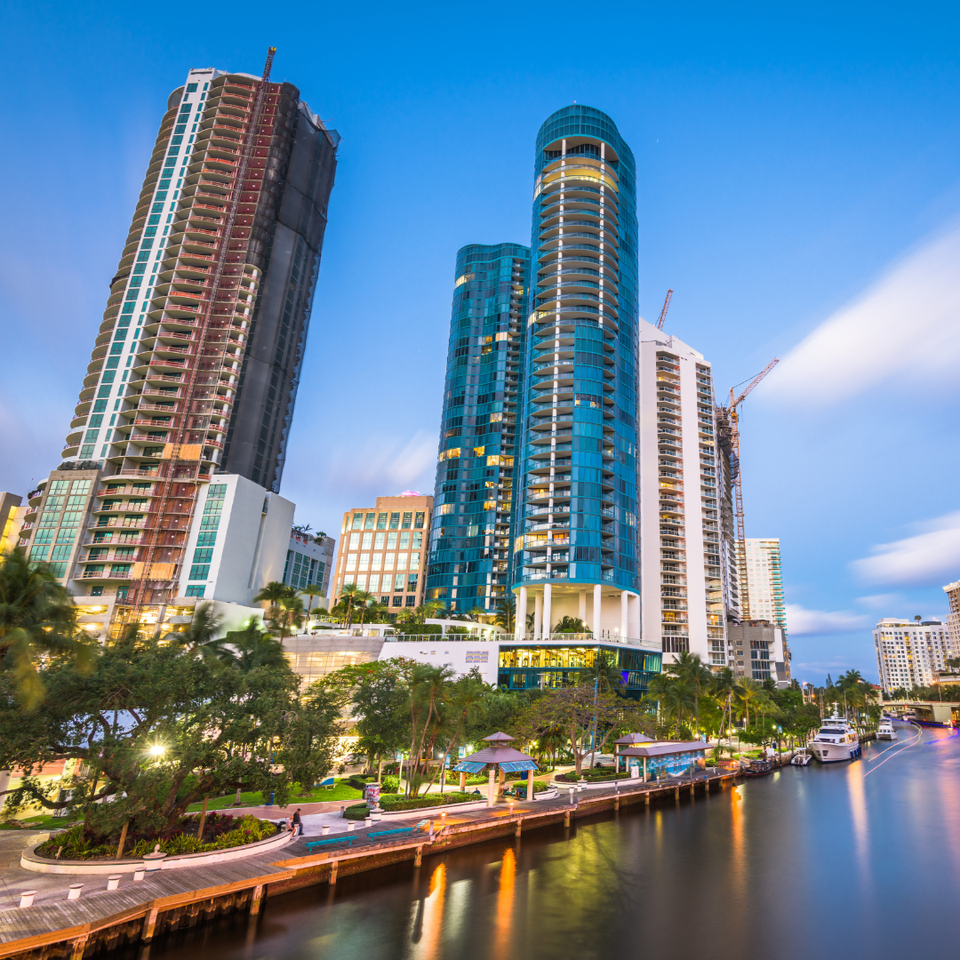 A city with a lot of tall buildings and a river in the foreground.