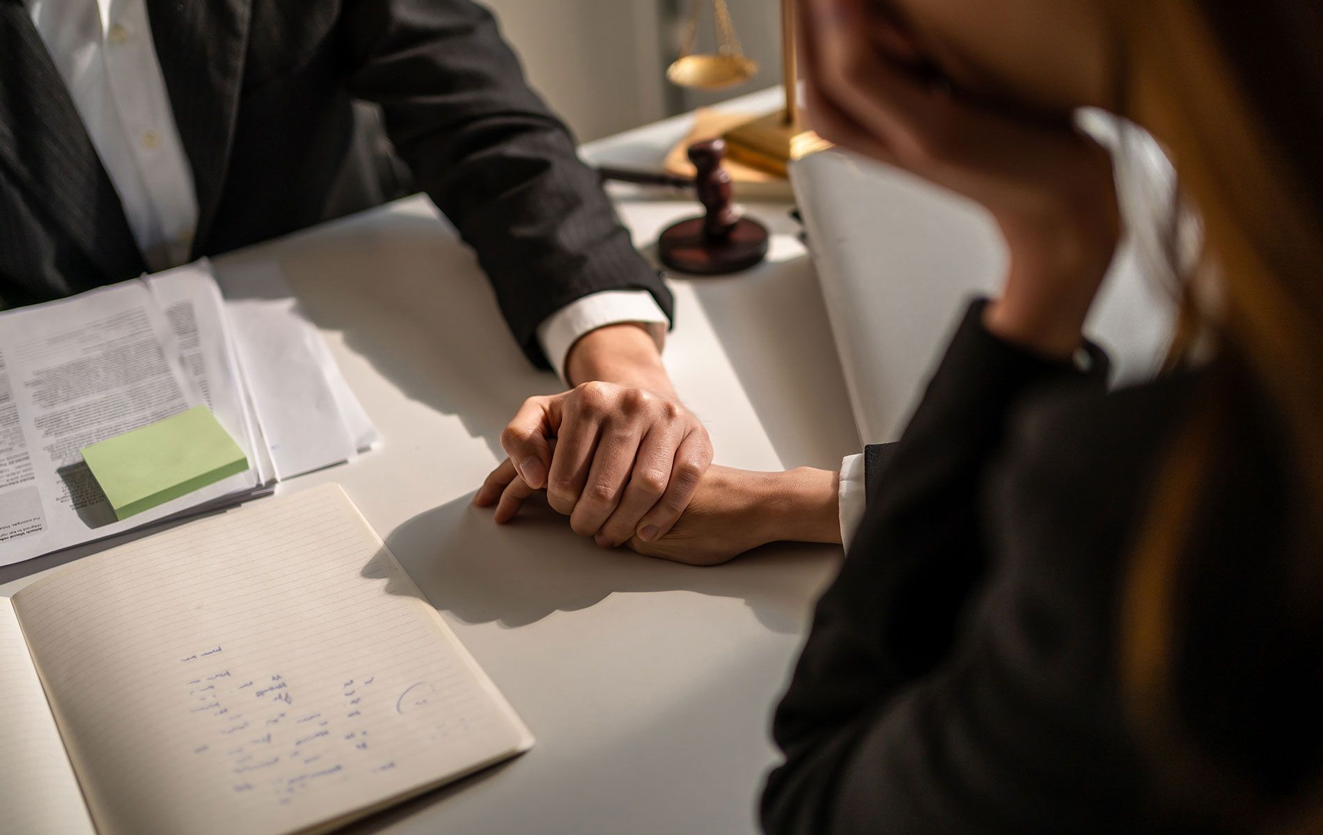 A man and a woman are sitting at a table holding hands.