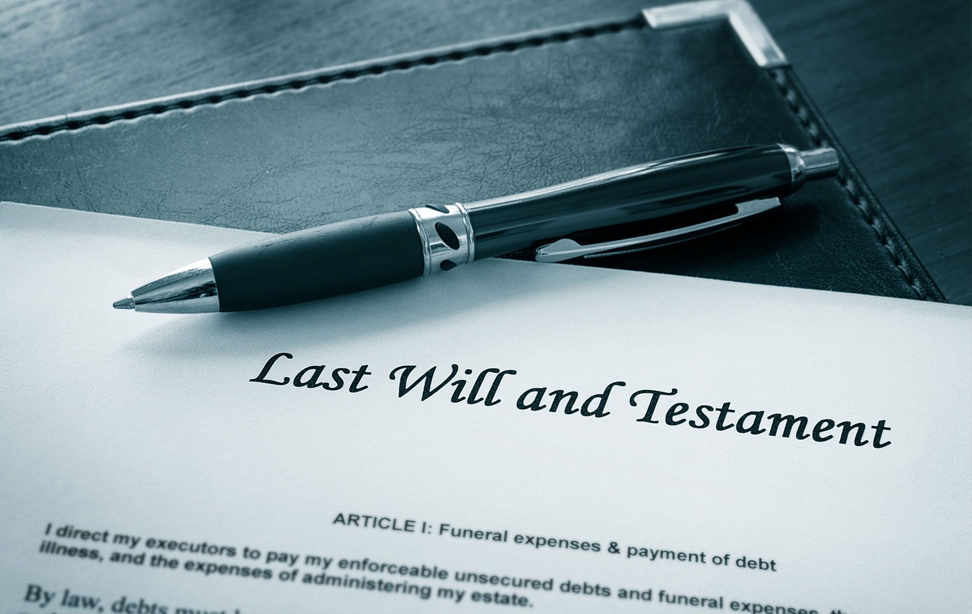 A pen is sitting on top of a last will and testament