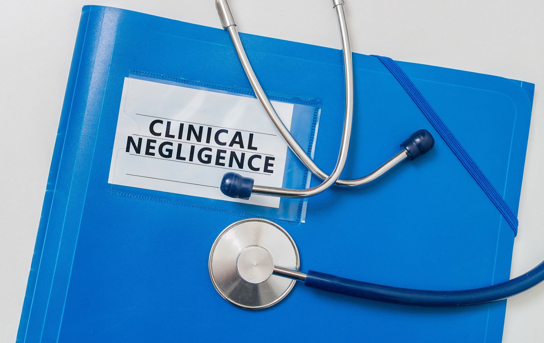 A stethoscope is sitting on top of a blue folder that says clinical negligence.