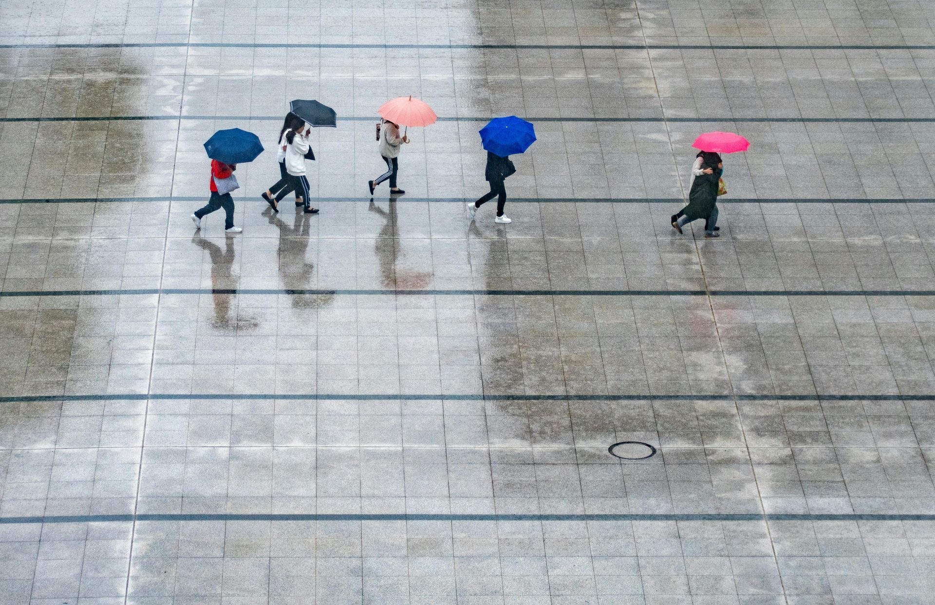 A bunch of people under umbrellas