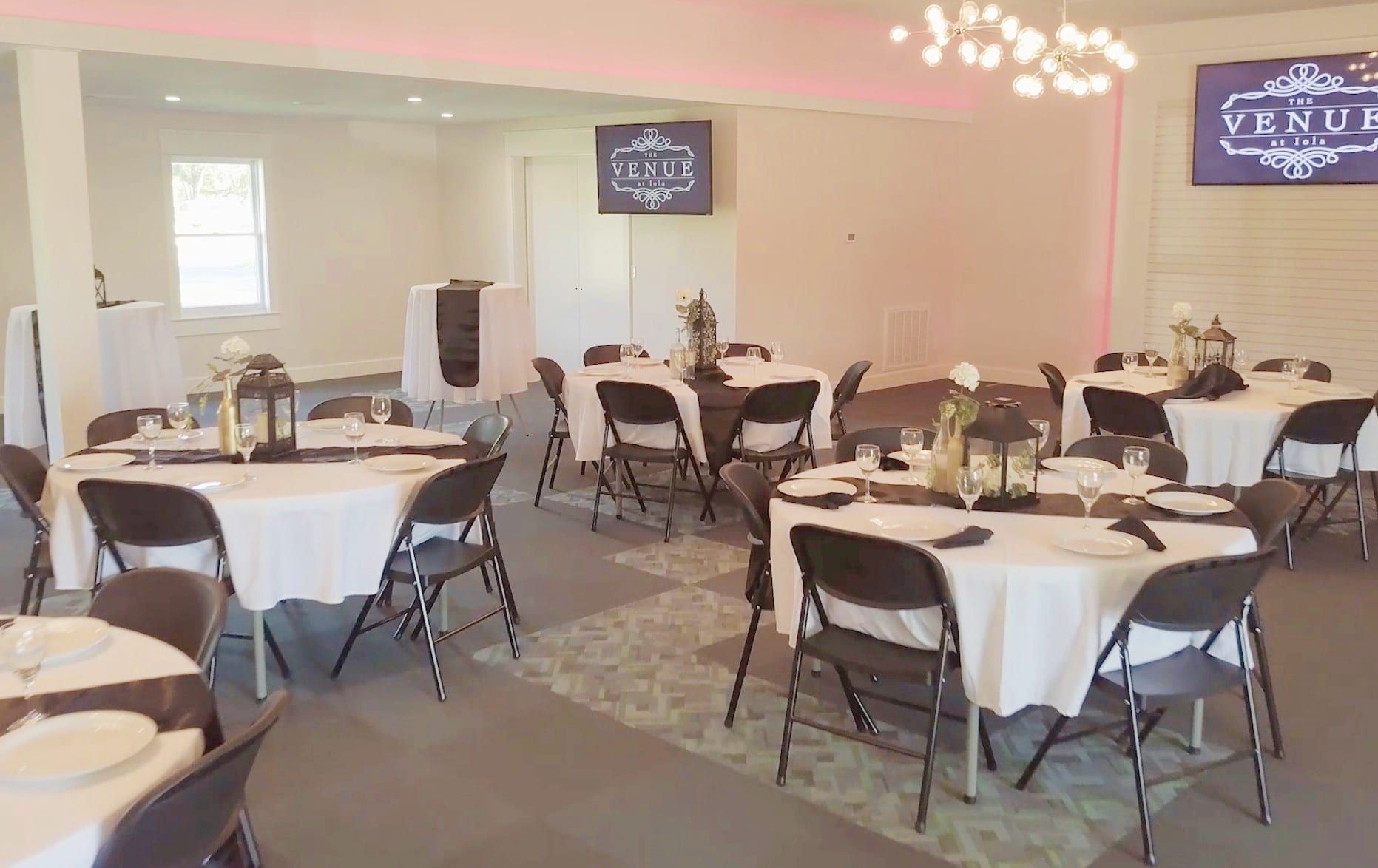 a large room with tables and chairs set up for a wedding reception .