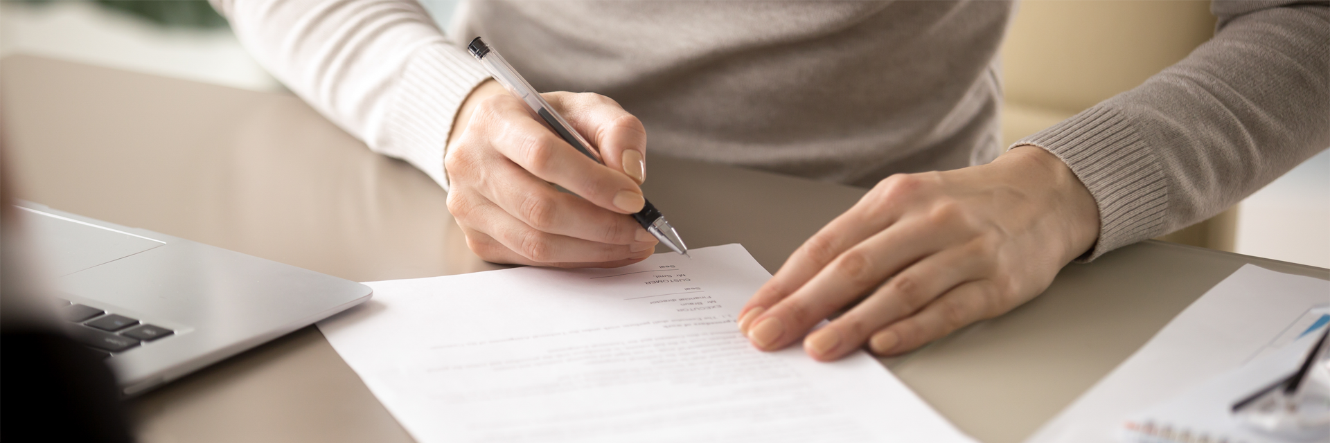 a person is writing on a piece of paper with a pen .