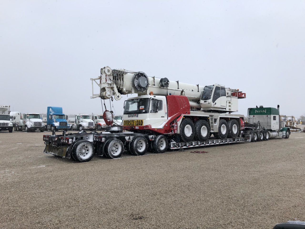 Crane on a flatbed trailer labeled