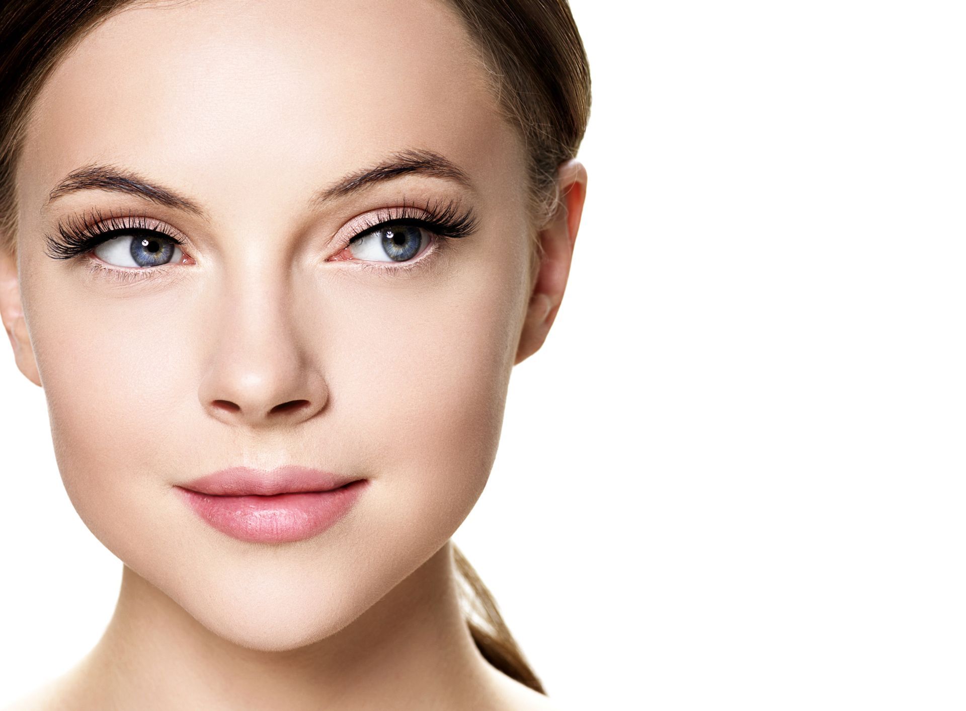 Close-up portrait of a woman with smooth skin and light makeup on a white background