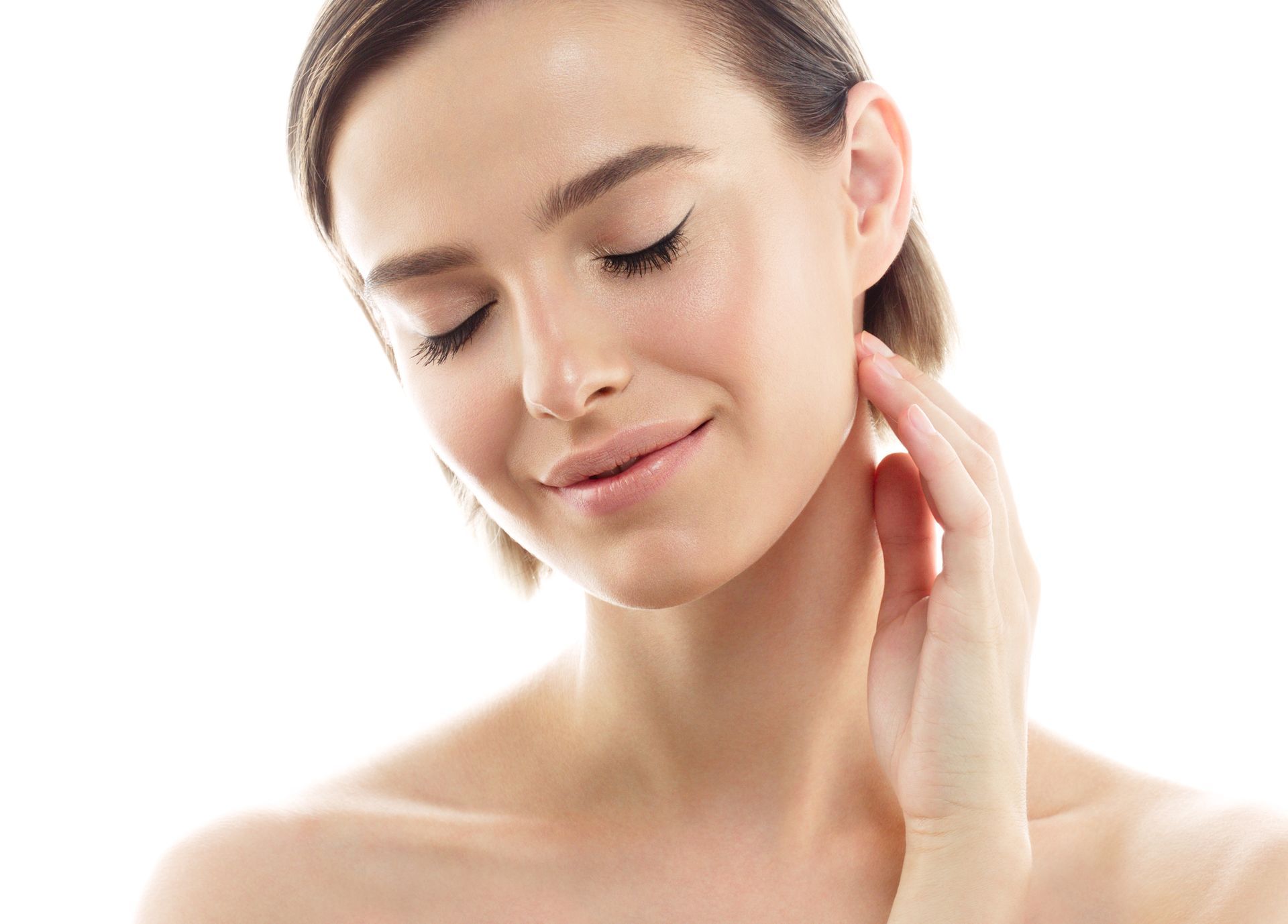 Woman with closed eyes, gently touching her neck. Fair skin, short hair, soft lighting.