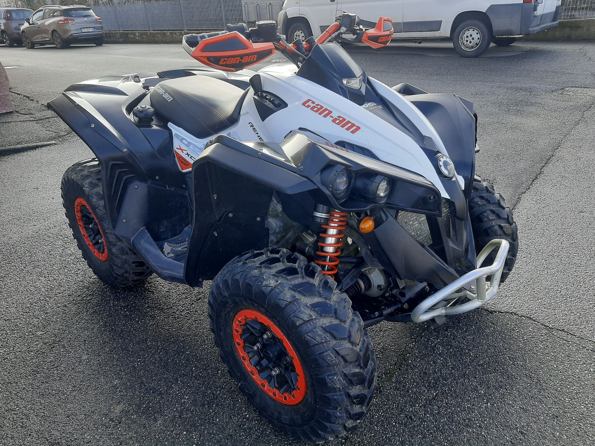 ATV Can-Am Renegade bianco e nero con dettagli arancioni parcheggiato all'esterno.