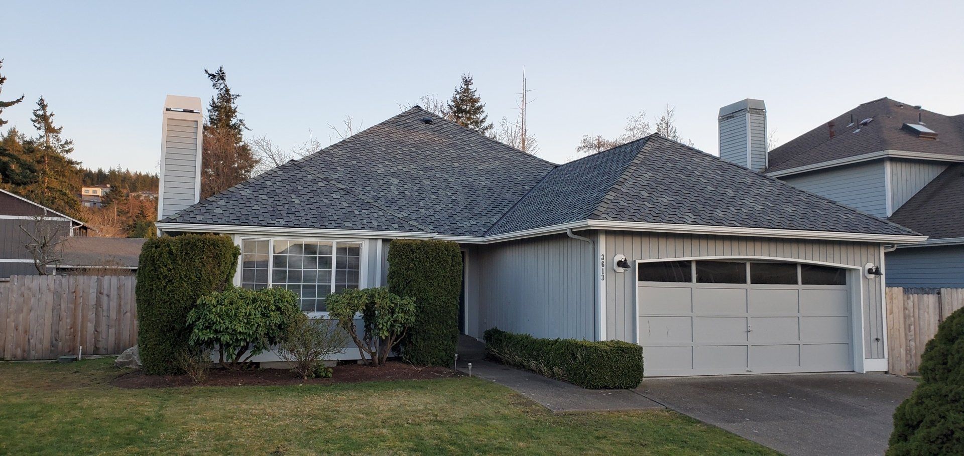 A house with a gray roof and a white garage door