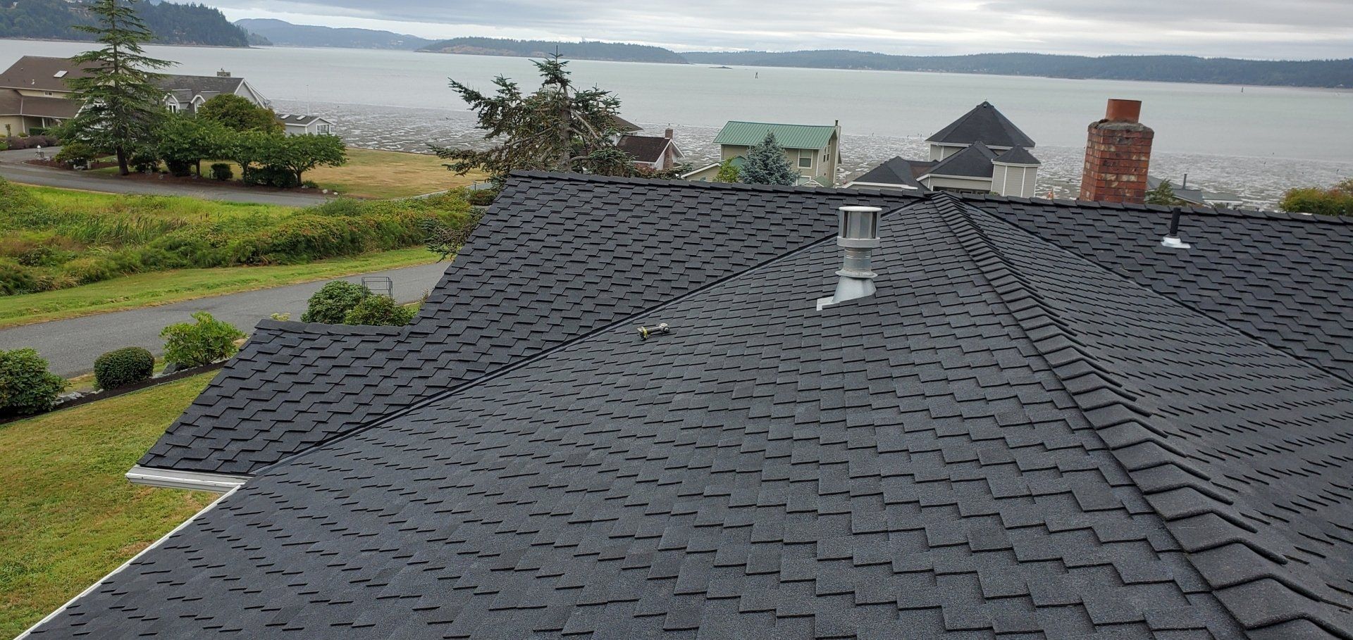The roof of a house with a view of the ocean.