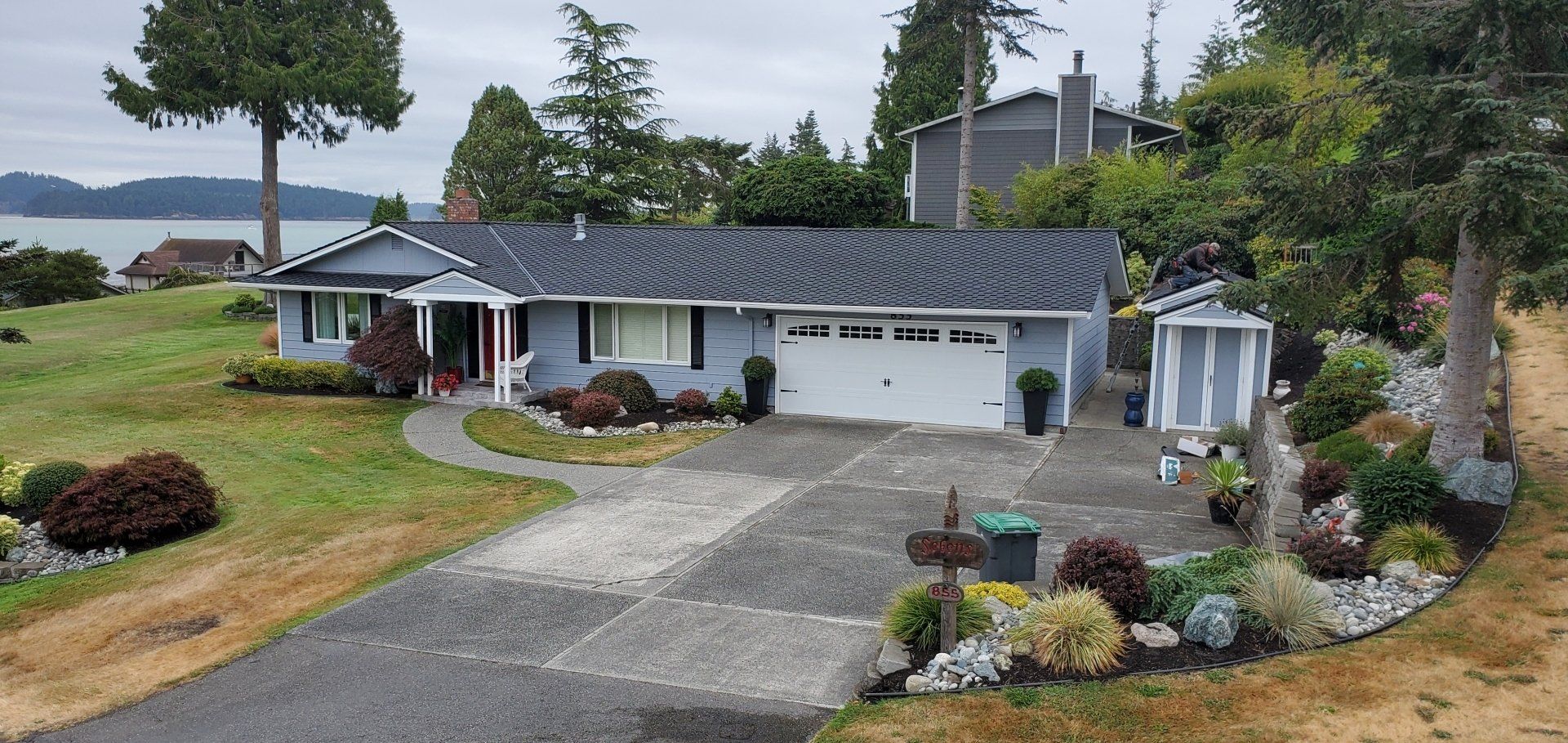 An aerial view of a house with a driveway leading to it.