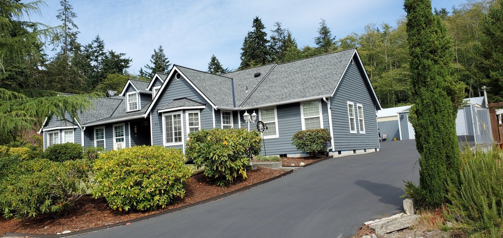 A large house with a lot of windows is surrounded by trees and bushes.