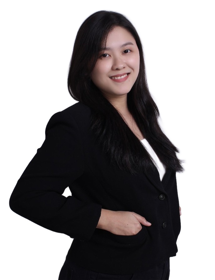 A smiling person with long dark hair, wearing a black blazer over a white top against a white background.