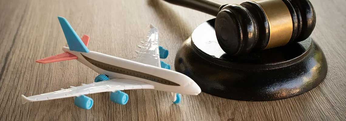Toy airplane beside a judge’s gavel on a textured surface