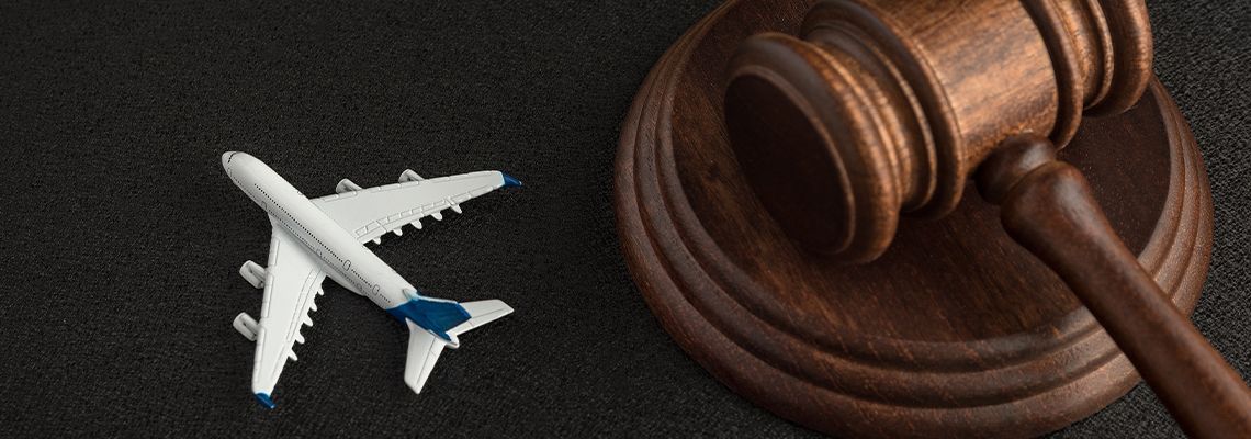 Toy airplane beside a judge’s gavel on a dark surface