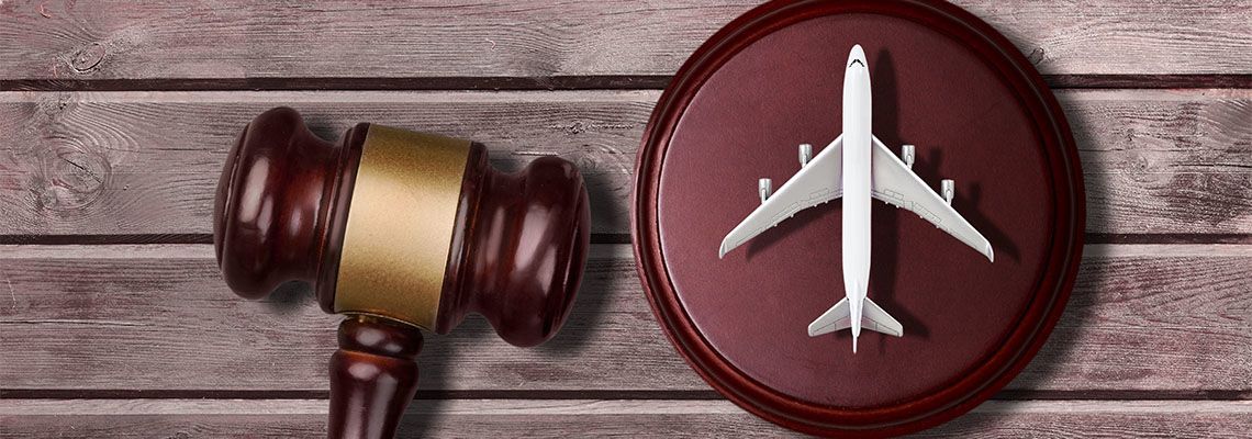 Gavel beside a toy airplane on a wooden surface, suggesting legal issues in aviation