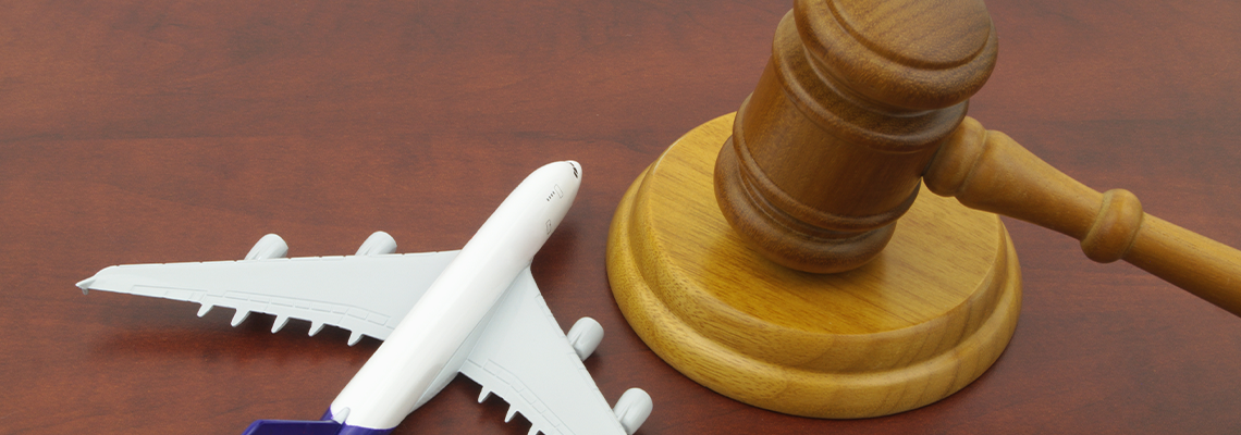 Toy airplane next to a wooden judge’s gavel on a desk