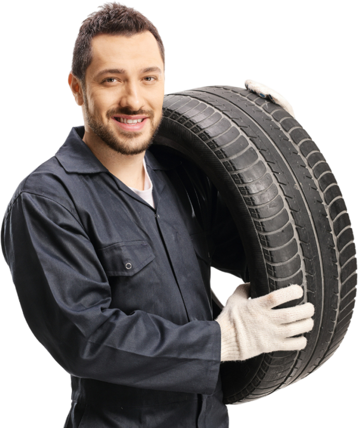A man is holding a tire in his hands and smiling.
