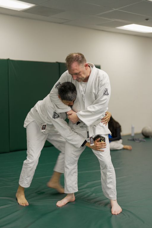 Adults practicing calm, technical grappling at Gracie Jiu-Jitsu San Jose in San Jose, CA for stress relief.