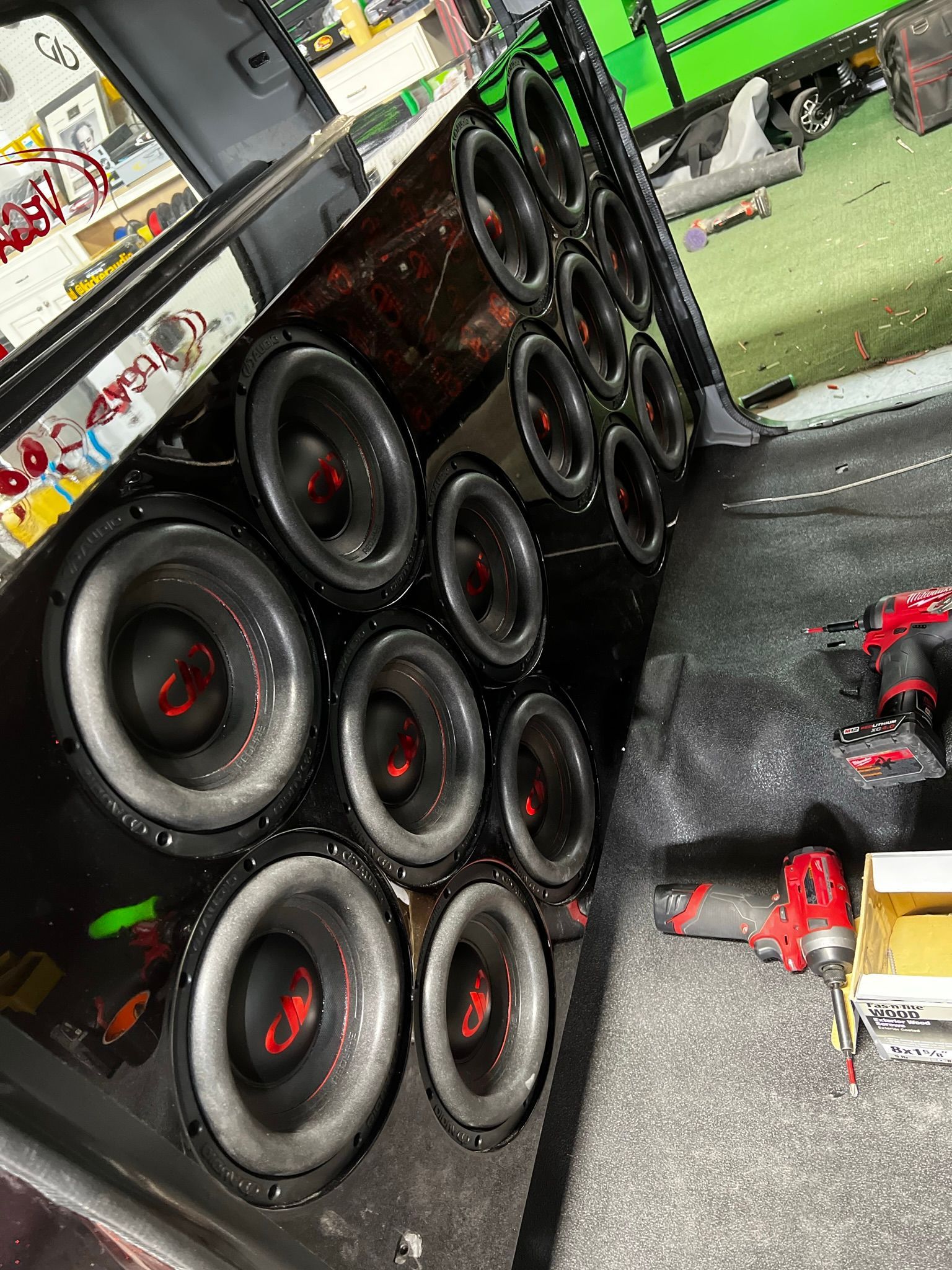 A bunch of speakers are stacked on top of each other in a car.