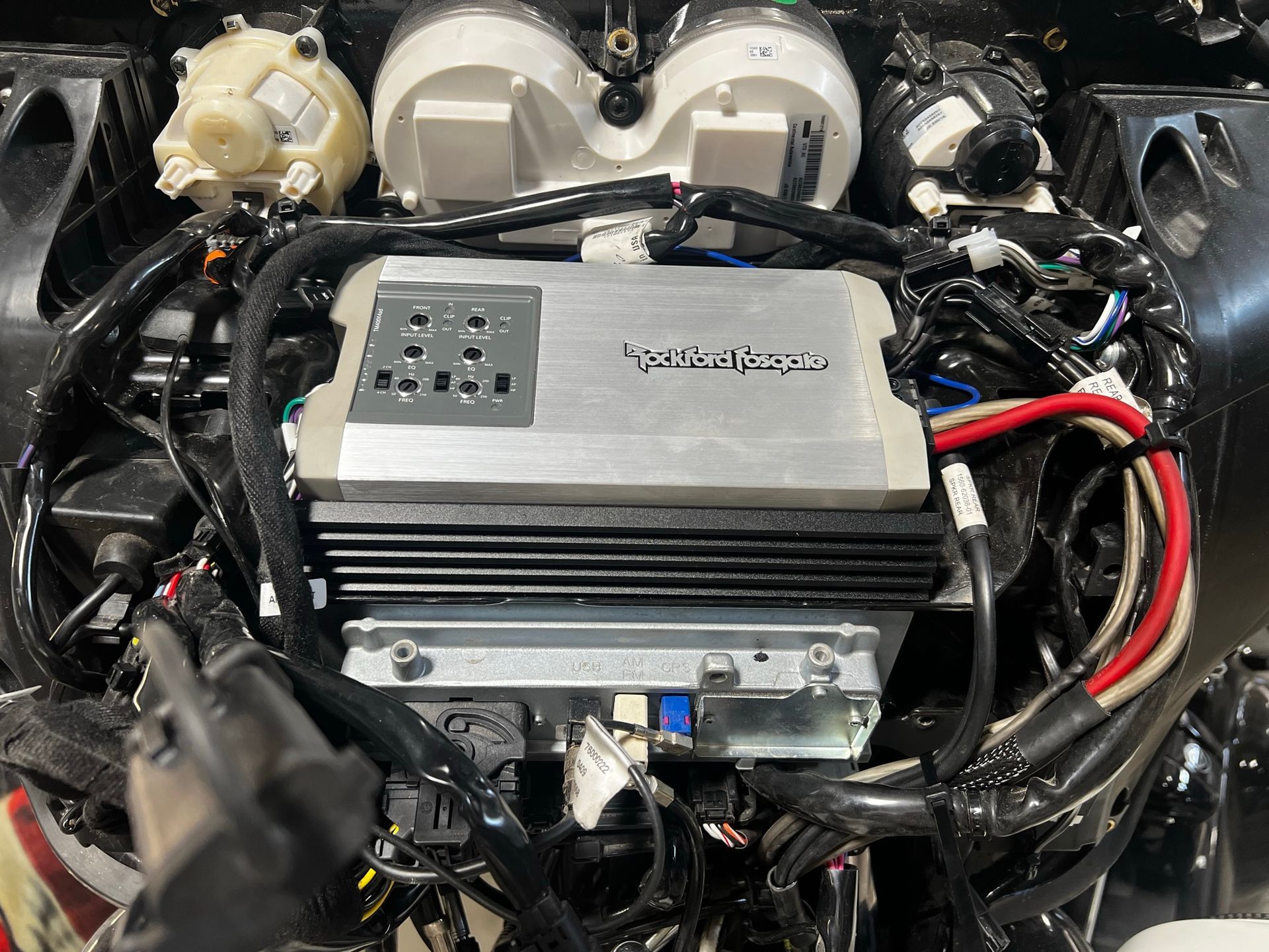 A close up of a car engine with a lot of wires coming out of it.