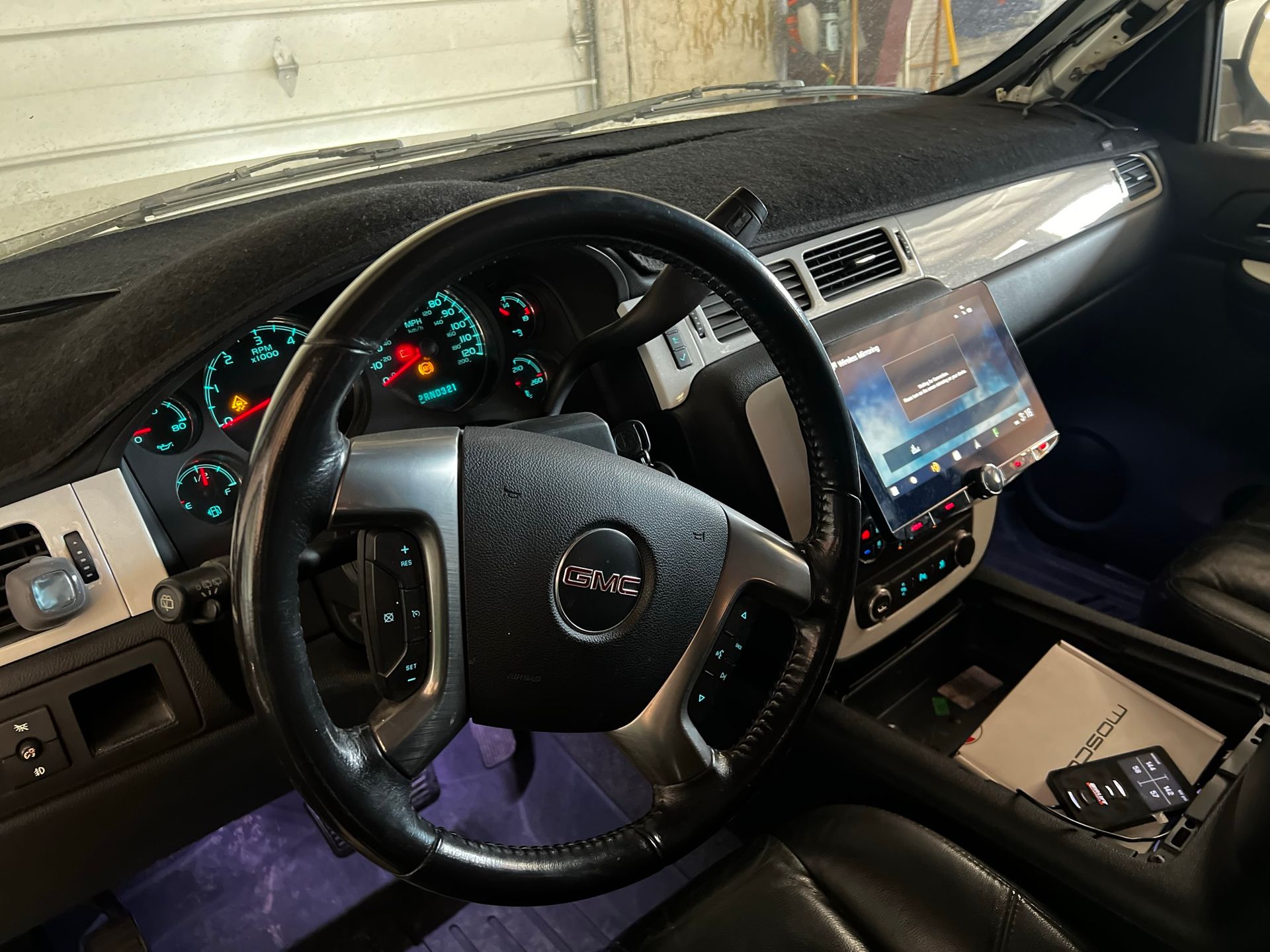 The interior of a gmc truck with a steering wheel and dashboard