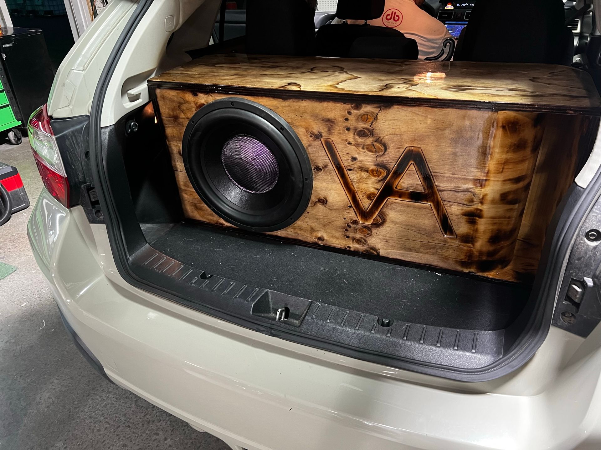 A wooden box is sitting in the back of a car.