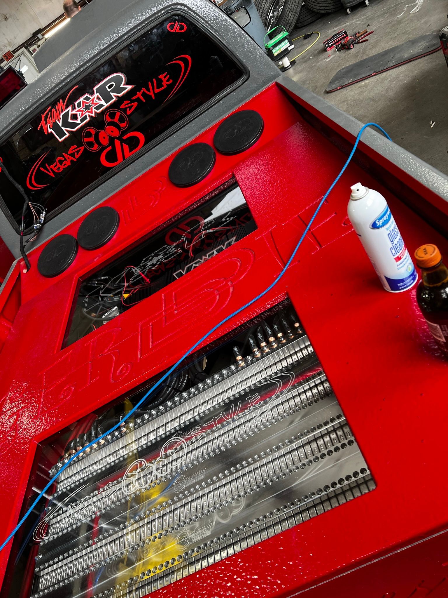 A red car with a spray bottle next to it.
