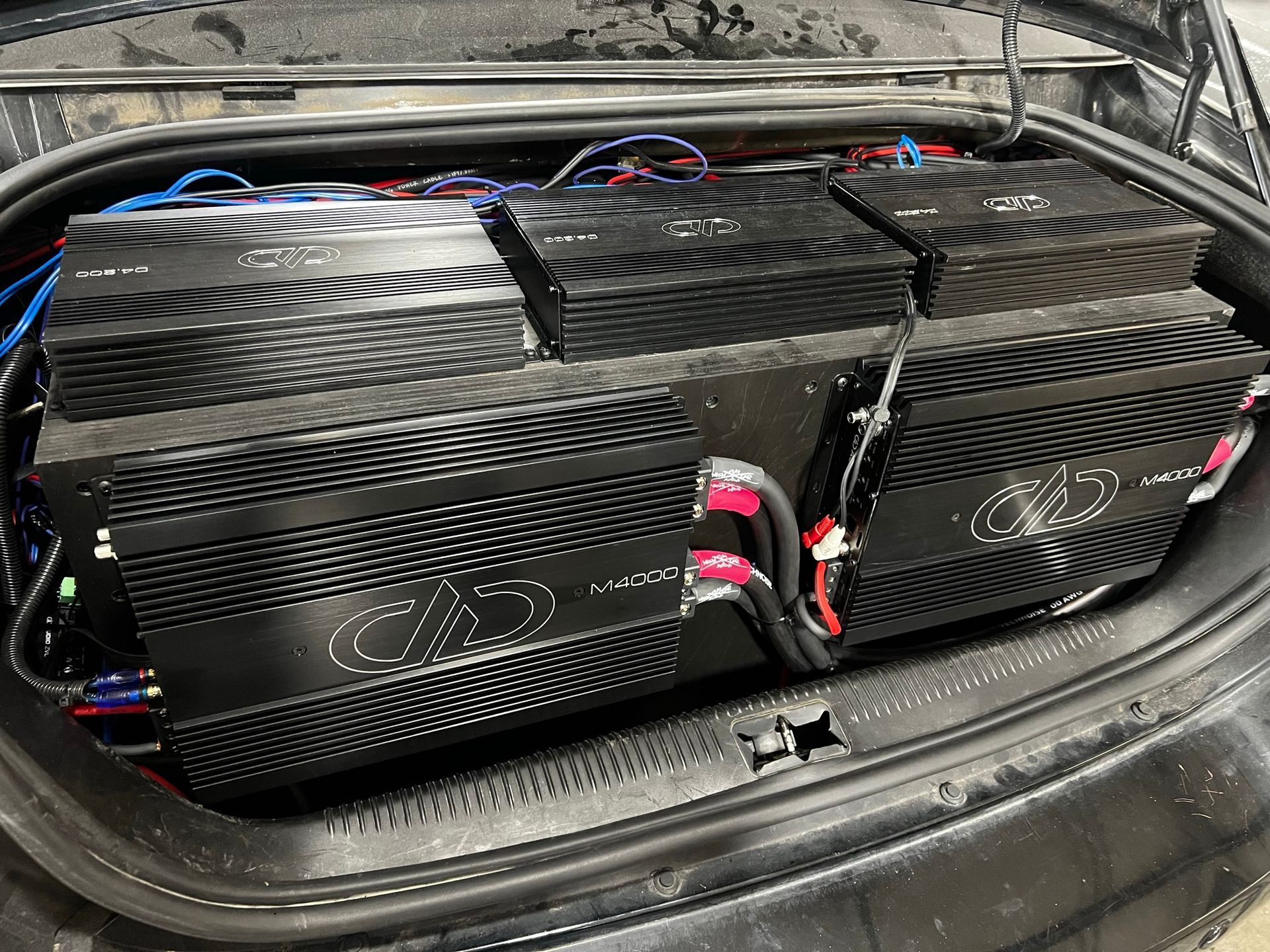 A bunch of amplifier boxes are sitting in the back of a car.