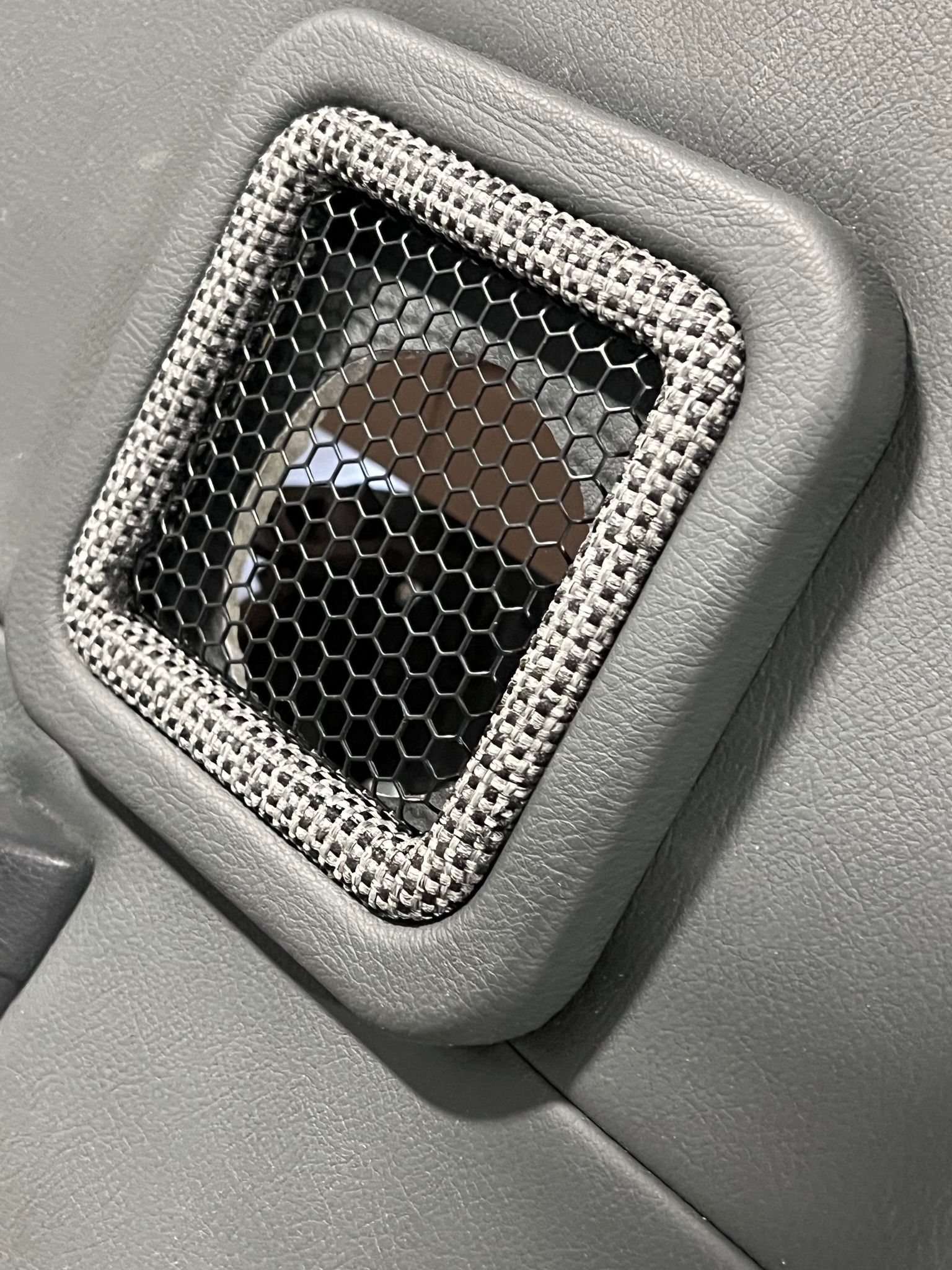 A close up of a speaker on a car door.