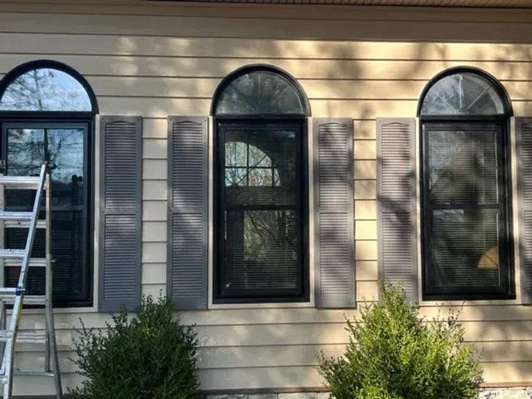 A house with three arched windows and black shutters.