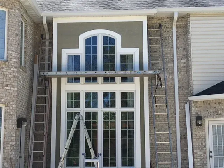 A large brick house with a ladder in front of it