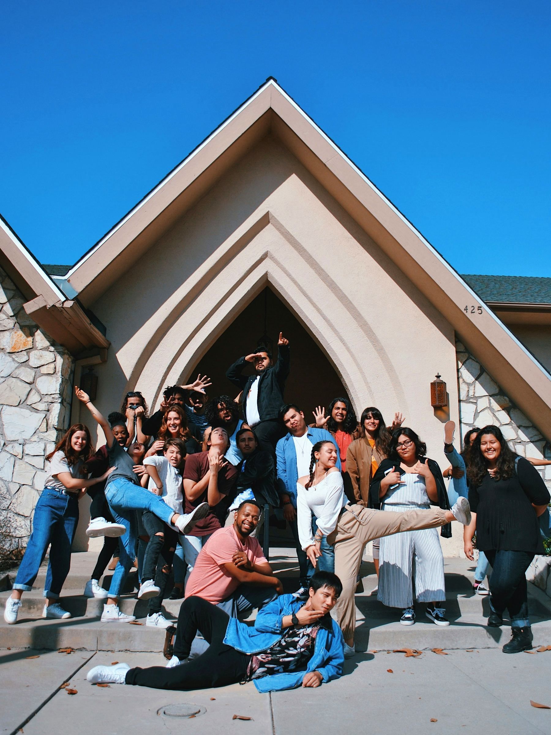 Young people gathered together on the steps of a church