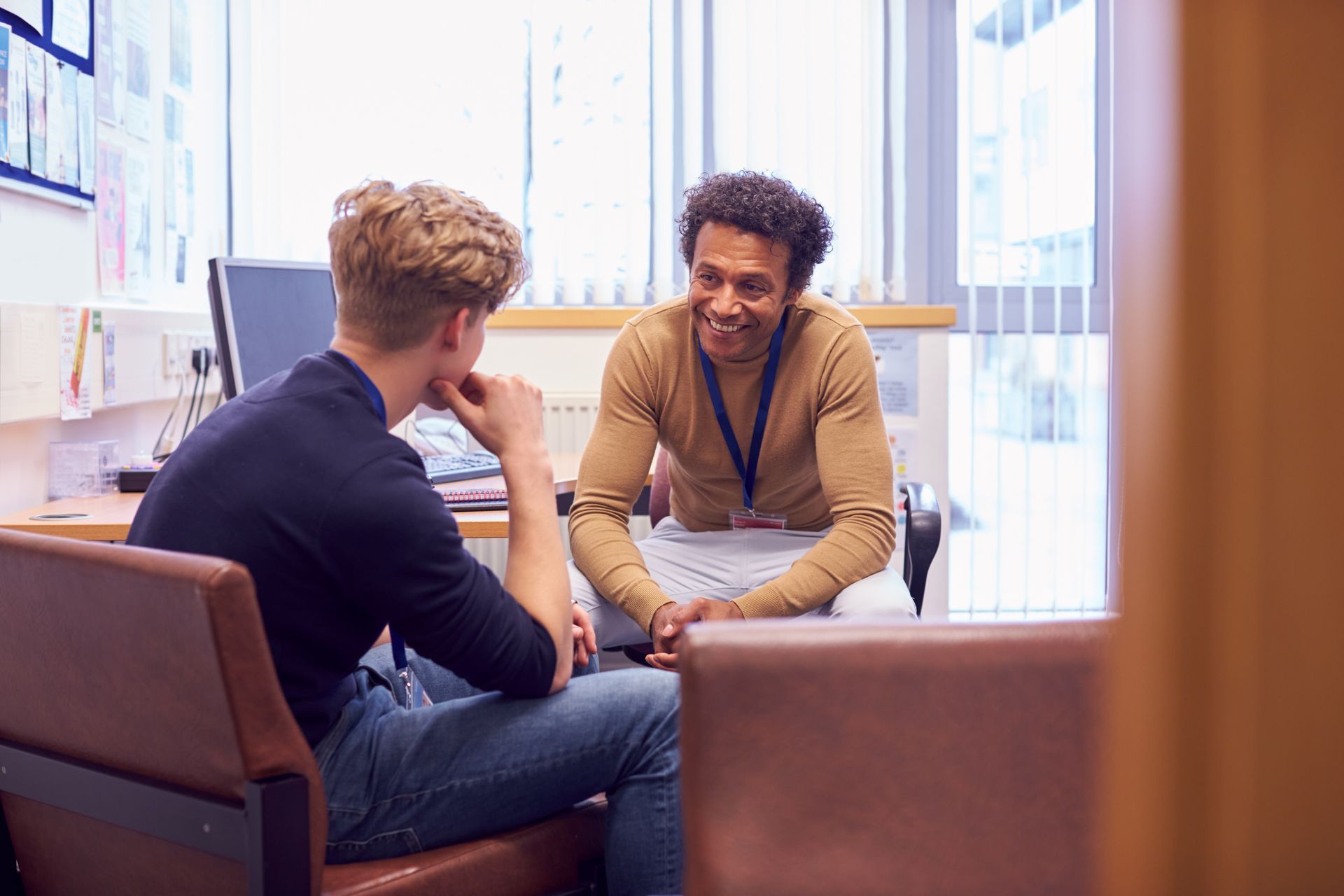 Smiling teacher talking with student.