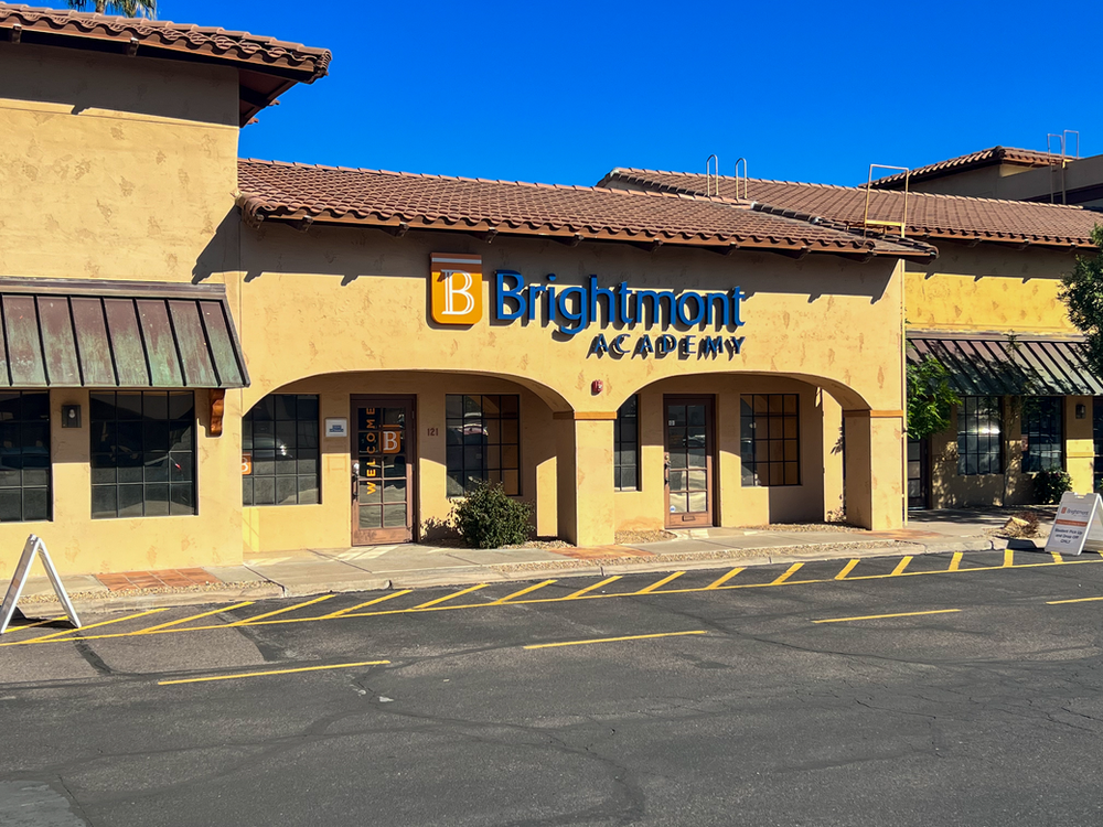 A brightmont academy building with a parking lot in front of it