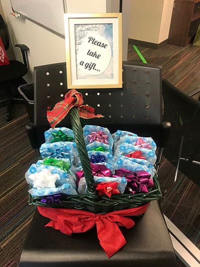 A basket filled with flowers and a sign that says please take a gift