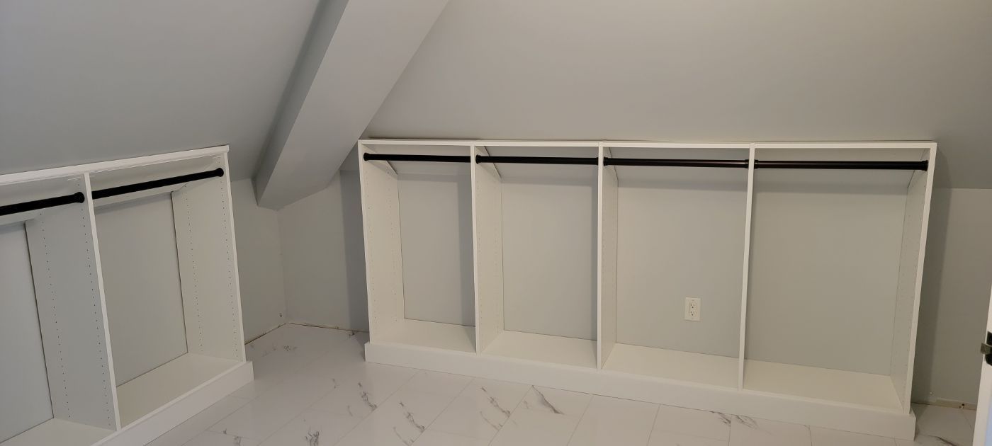 a walk in closet with lots of shelves and clothes racks .
