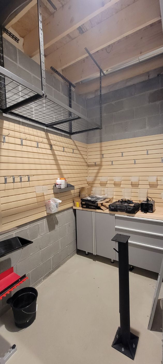 a kitchen in a garage with a lot of cabinets and a stove .