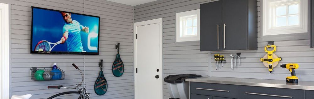 A bicycle is parked in a garage next to a flat screen tv.