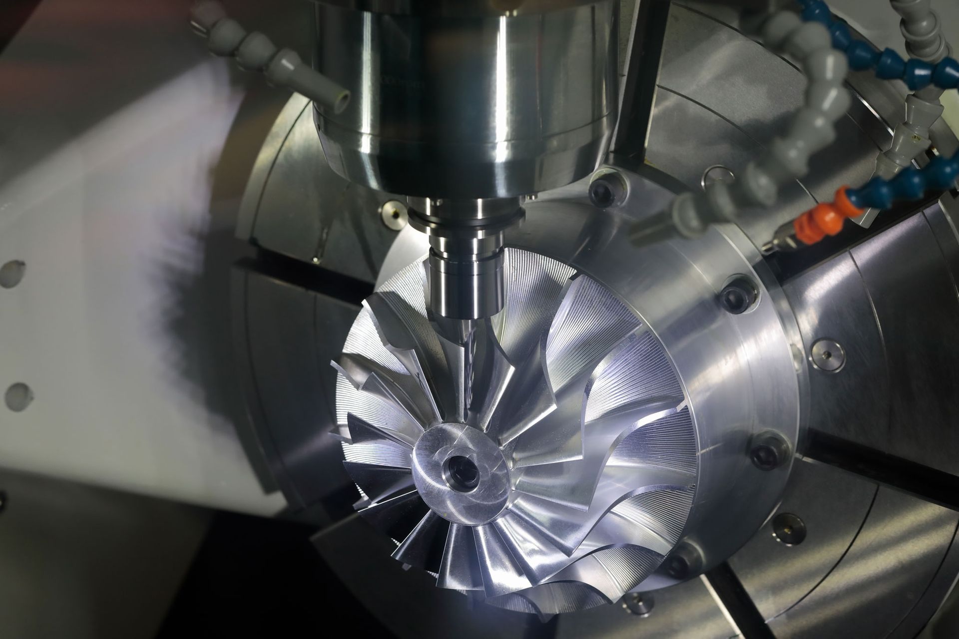 A machine is cutting a piece of metal that looks like a fan