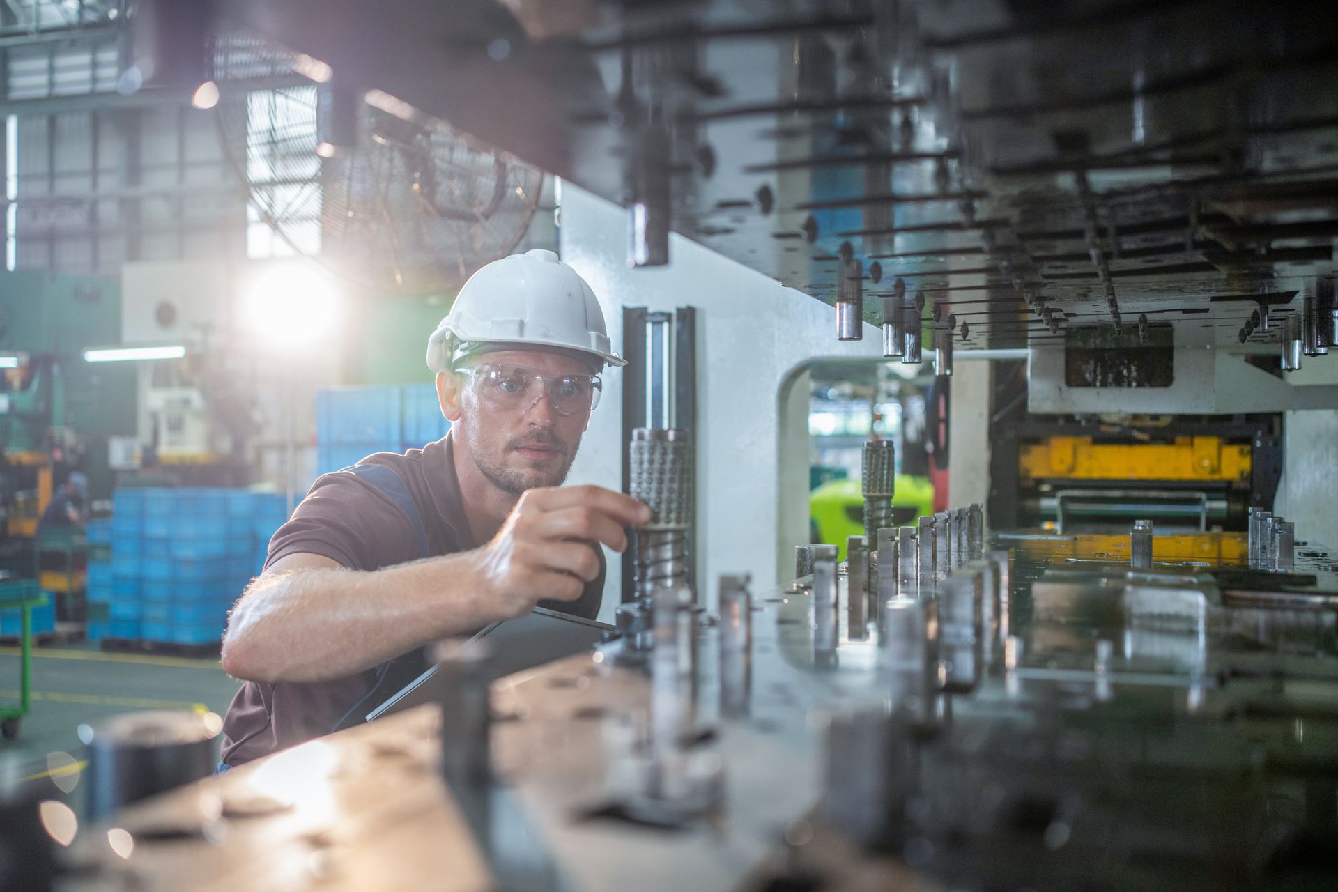 Factory worker is programming a CNC milling machine with a tablet computer. Factory worker is programming a CNC milling machine with a tablet computer.