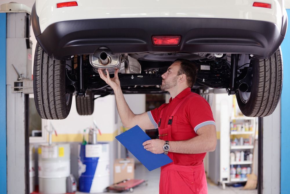 Inspectors Examining the Car Exhaust System — A1 Safety Certificates & Repairs in Gordonvale, QLD