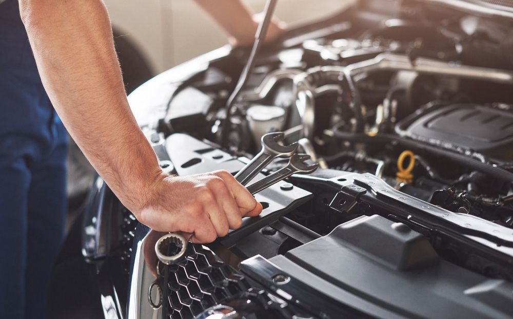 Men Inspecting Engine While Holding a Wrench — A1 Safety Certificates & Repairs in Gordonvale, QLD