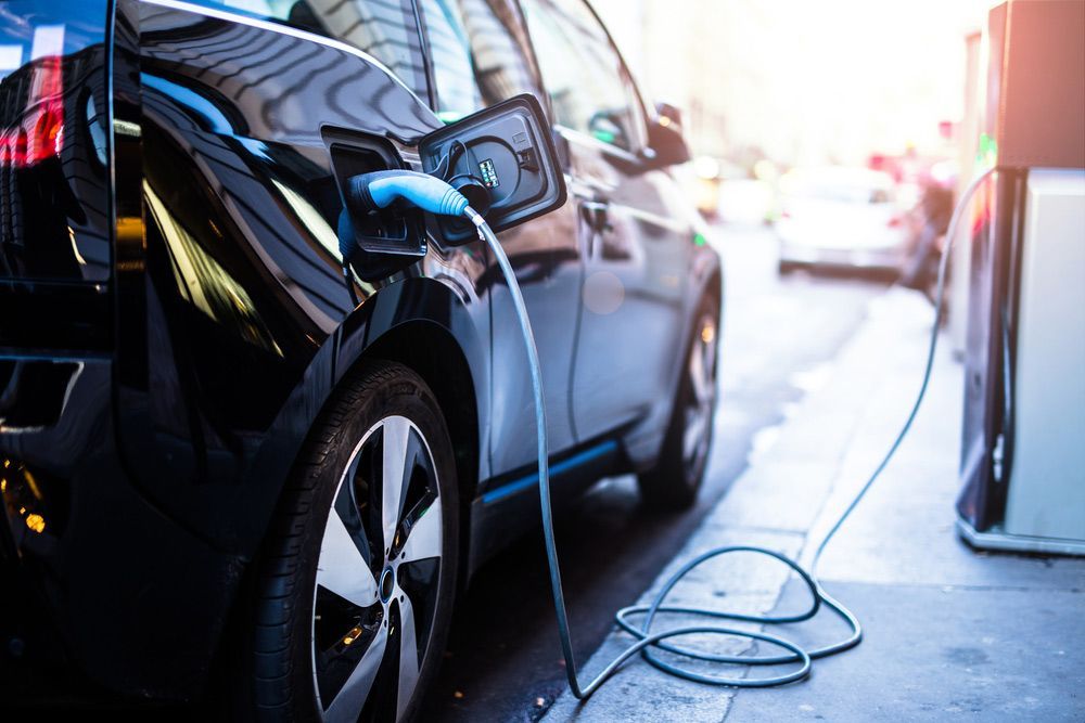 An Electric Car Is Being Charged at A Charging Station — Ryde Energy in Flagstone, QLD