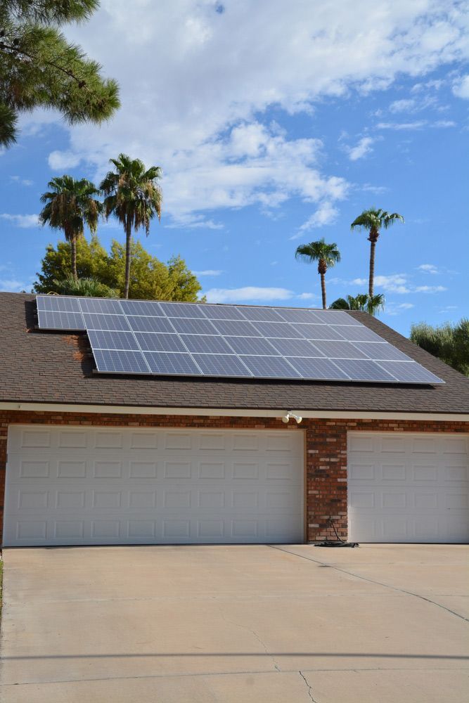 A House with Two Garage Doors and Solar Panels on The Roof — Ryde Energy in Browns Plains, QLD