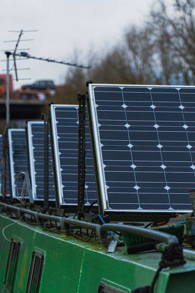 A Row of Solar Panels Are Sitting on Top of A Green Equipment — Ryde Energy in Logan, QLD