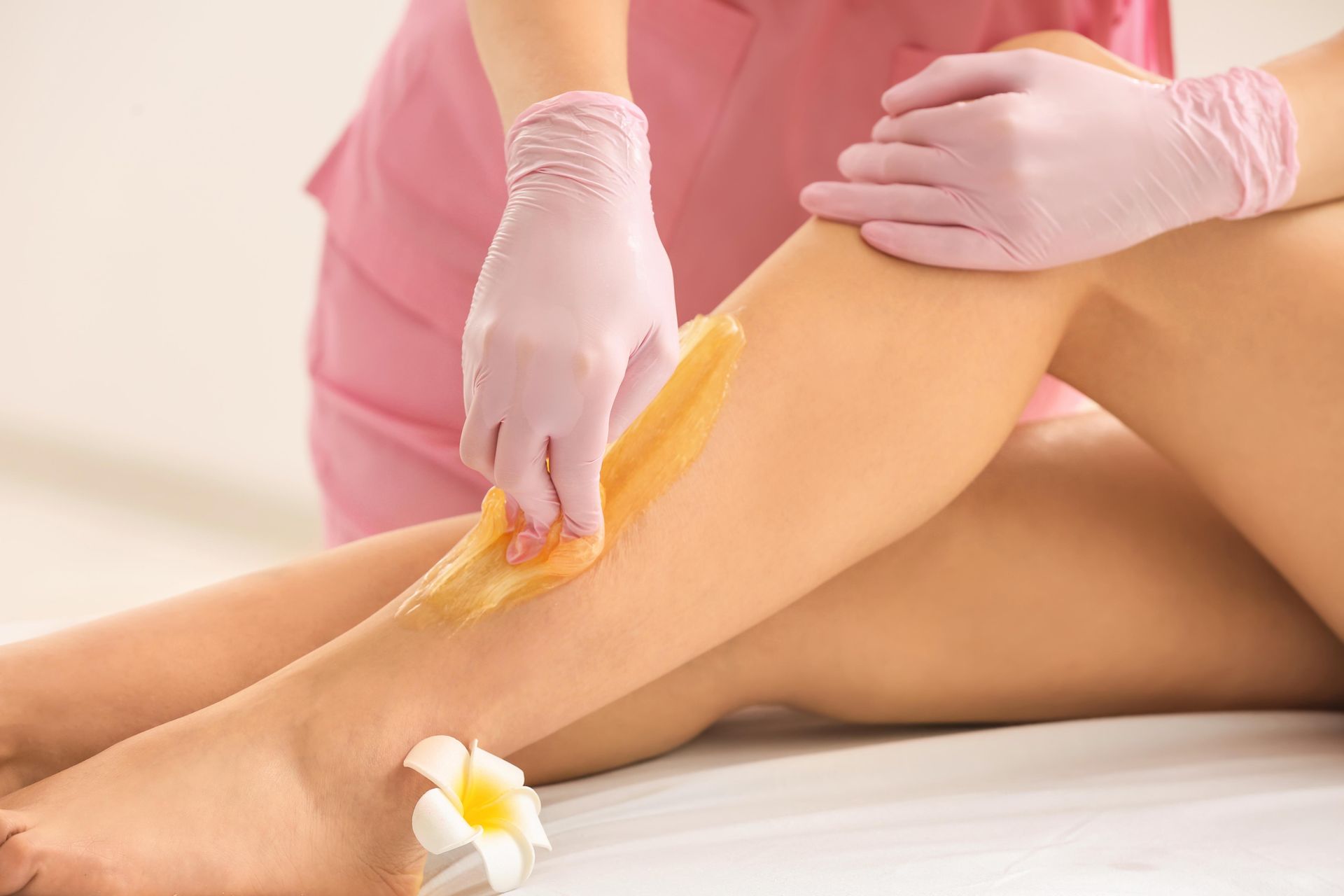 A woman is getting her legs waxed in a beauty salon.