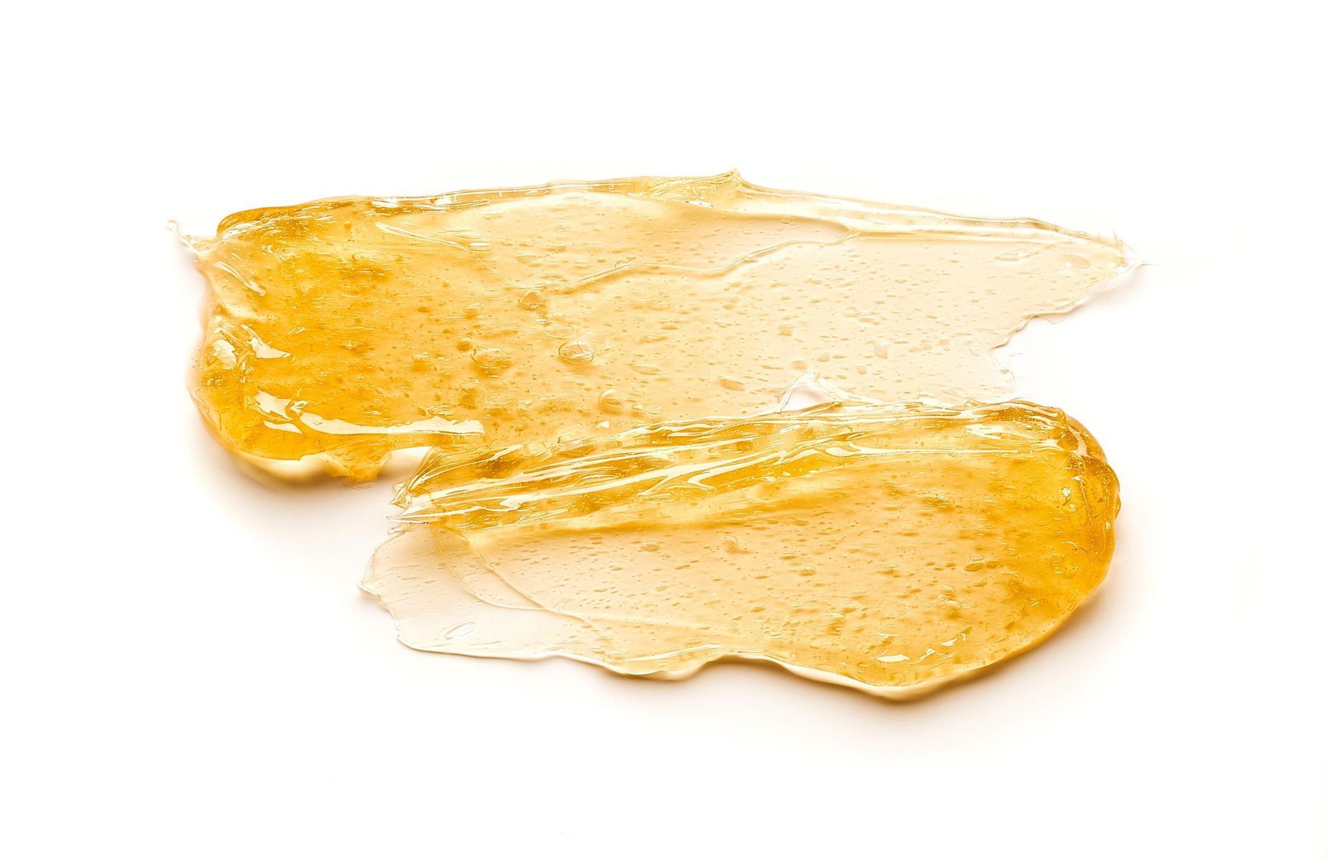 A close up of a piece of honey on a white background.