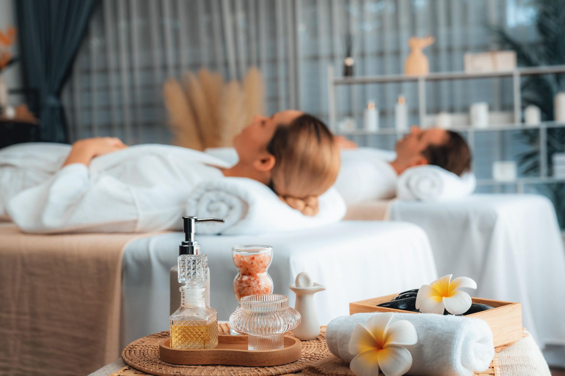 A man and a woman are laying on massage beds in a spa.