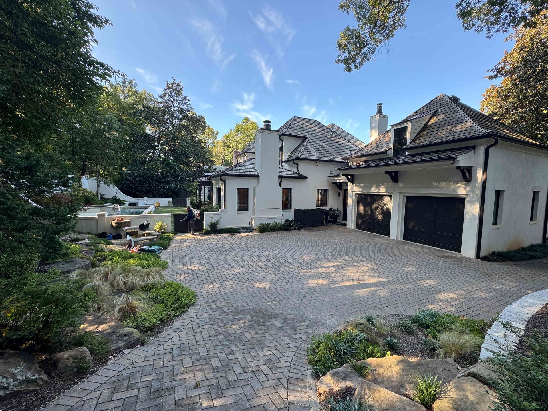 Modern house with gray driveway, garage, garden, and blue sky